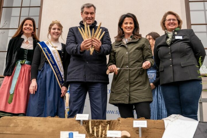 Ministerpräsident Söder, Ministerin Kaniber, Spargelkönigin und weitere Verantwortliche im Gruppenbild vor Spargel-Demo-Feld