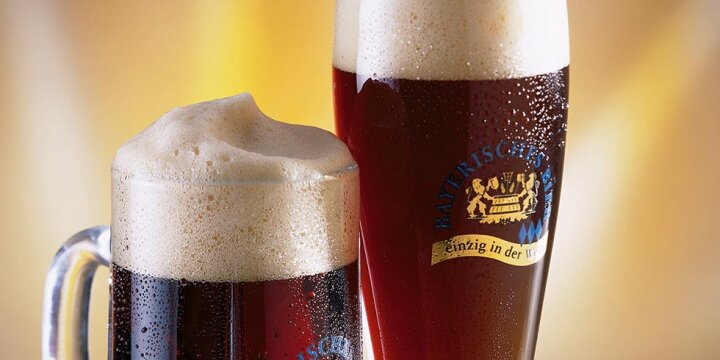 Nahaufnahme von zwei dunklen Bieren in zwei verschiedenen Gläsern, Krug und Weizenglas
