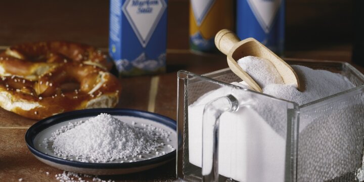 ein Schälchen Salz, daneben ein Gewürzglasbehälter, im Hintergrund eine Salzbrezel und Verpackungen