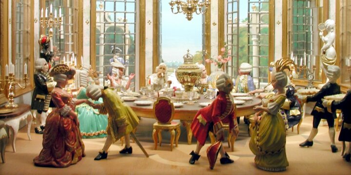 Porzellanfiguren stellen eine barocke Essensszene dar